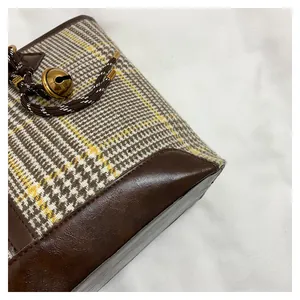 Detail of wool fabric houndstooth pattern and leather trim with gold bell ornament