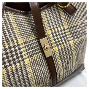 Detail of golden metal twist lock on retro brown houndstooth wool fabric tote bag