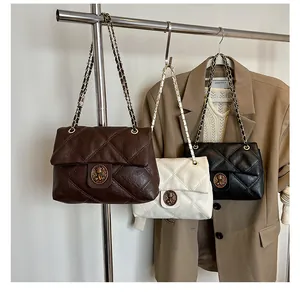 Details von gesteppten Vintage-Kettentaschen in Braun, Creme und Schwarz mit Metallschließe