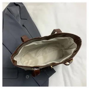 Top view of spacious interior lining and houndstooth fabric of the tote bag