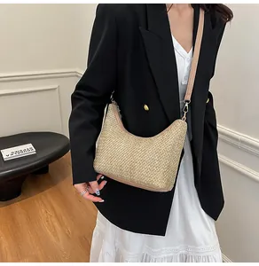 Détail du sac hobo en paille avec garniture en cuir sur mannequin au décor épuré