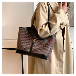 Detail of vintage houndstooth tote bag with brown plaid fabric and gold metal buckle