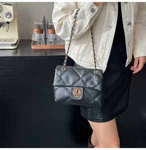Detail der schwarzen Stepptasche aus Leder mit Vintage-Bärenverschluss und Metallkette