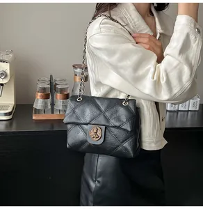 Details einer schwarzen Stepptasche mit Vintage-Goldverschluss und Kettenriemen