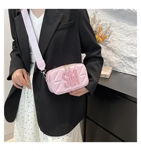 Detail van roze gewatteerde crossbodytas met brede schouderband en SM-logo reliëf