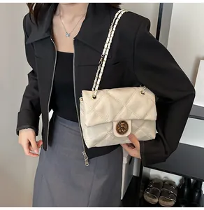 Details der beige gesteppten Umhängetasche mit Metallkette und Retro-Verschluss