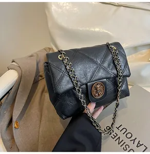 Makroaufnahme der schwarzen gesteppten Kunstledertasche mit goldener Reliefschnalle