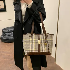 Large plaid tweed tote bag with leather handles and gold lock shown on model