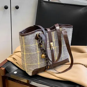 Classic plaid tweed tote bag with brown leather handles and decorative golden clasp