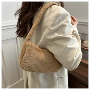Detailed side view of the warm camel faux fur underarm bag worn by a model