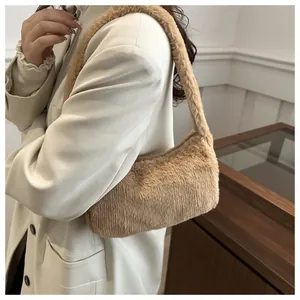 Detail shot of a soft beige faux fur hobo bag worn as a stylish underarm shoulder bag