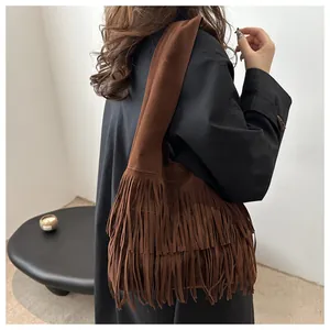 Close-up of the long suede fringe layers and rich texture of the brown hobo bag