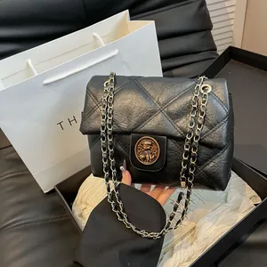 Gesteppte schwarze Ledertasche mit goldenem Bärenverschluss und Metallkettenriemen
