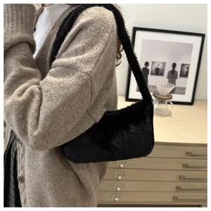 Detail of black plush faux fur shoulder bag worn with an autumn knit outfit