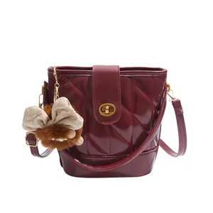 Sac seau matelassé rouge bordeaux avec fermoir doré et pendentif en peluche