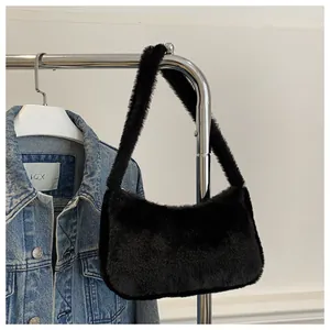 Detail of soft black faux fur shoulder bag texture with minimalist underarm strap design