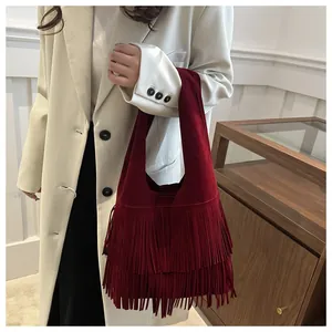 Detail of burgundy faux suede tote bag featuring bohemian double-layered fringe tassels