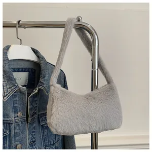 Detail view of light grey faux fur shoulder bag texture hung over denim jacket