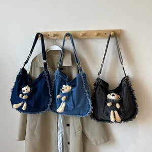 Three denim tote bags with fringe trim and cute bear charms in blue and grey colors