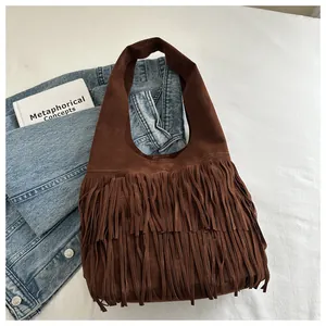 Macro detail of dark brown faux suede material and long fringe on the vintage tote bag