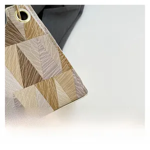 Gros plan sur le motif tissé géométrique avec des œillets métalliques dorés sur le sac