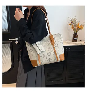 Détail du grand sac cabas en toile beige avec finitions en cuir marron et petite pochette