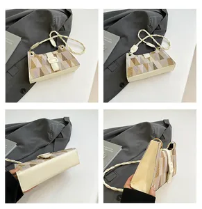 Détail du motif géométrique bicolore sur sac à bandoulière avec sangle tissée et boucle