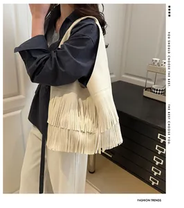 Close-up of cream-colored hobo bag with tiered long tassels and pebbled leather texture