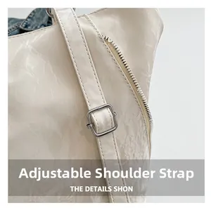 Detail of adjustable shoulder strap with metal buckle on cream faux leather tote bag