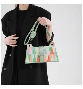 Détail du motif géométrique coloré et de la poignée en corde tressée verte du sac