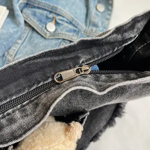 Close-up of metal zipper detail and frayed denim edges on black tote bag