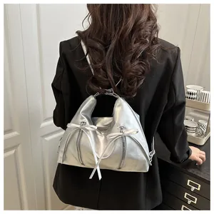 Détail du sac à bandoulière en PU argenté métallisé avec nœuds et double fermeture éclair