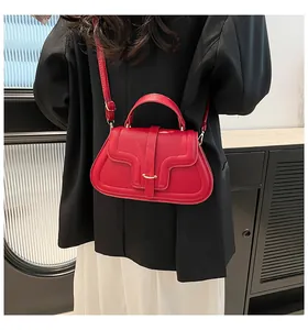 Detailed back view of a red PU leather handbag featuring a curved flap and gold metal buckle
