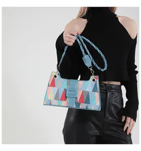 Détail du sac à bandoulière coloré avec motifs géométriques et bandoulière en cuir bleu