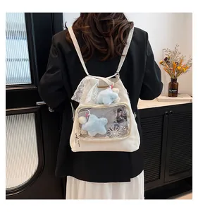 Detail of white canvas ita bag with transparent front pocket and star plush accessory