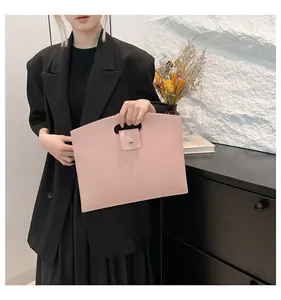 Détail du sac cabas en cuir rose avec poignée évidée et fermeture par bouton-pression