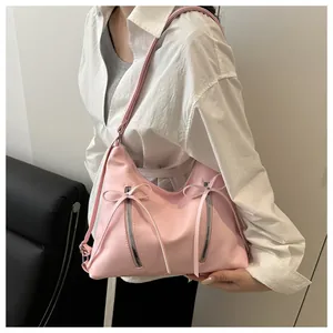 Detail of light pink PU leather handbag with balletcore bow and dual zippers
