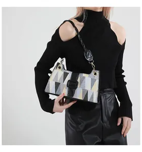 Détail d'un sac à bandoulière à motifs géométriques avec lanière noire sur mannequin