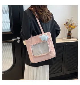 Detail of pink ita bag with transparent PVC window and star plush charm accessory