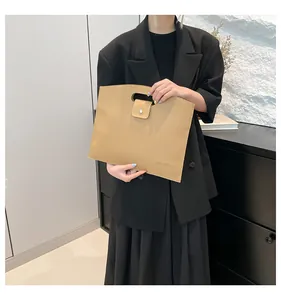 Détail du sac d'ordinateur en cuir grainé marron clair avec poignée et fermeture pression