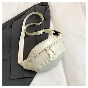Detail of minimalist cream PU leather chest bag featuring double zippers and nylon strap