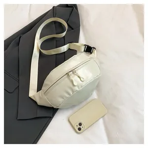 Close-up of cream leather waist bag on a grey blazer with smooth texture and zippers