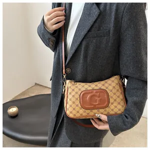 Brown monogram crossbody bag with embossed G detail and sleek leather shoulder strap