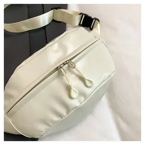 Detail of cream white PU leather crossbody bag with dual zippers and adjustable strap
