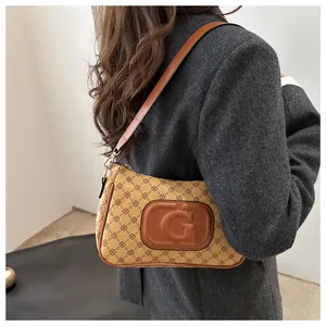Detail of khaki monogram shoulder bag with embossed G logo and brown leather strap