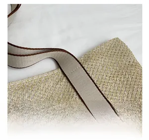 Detailed macro view of beige woven straw bag featuring contrast-stitched canvas strap