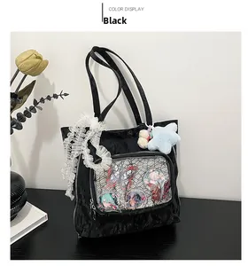 Detail of black ita bag with clear PVC window showing anime badges and lace trim