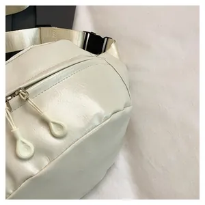 Detail of cream white PU leather fanny pack with glossy finish and durable buckle