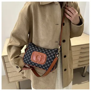 Brown leather strap and gold buckle detail on a vintage monogram crossbody bag