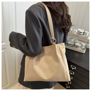 Close-up of beige canvas tote bag showing thick woven texture and gold metal ring detail